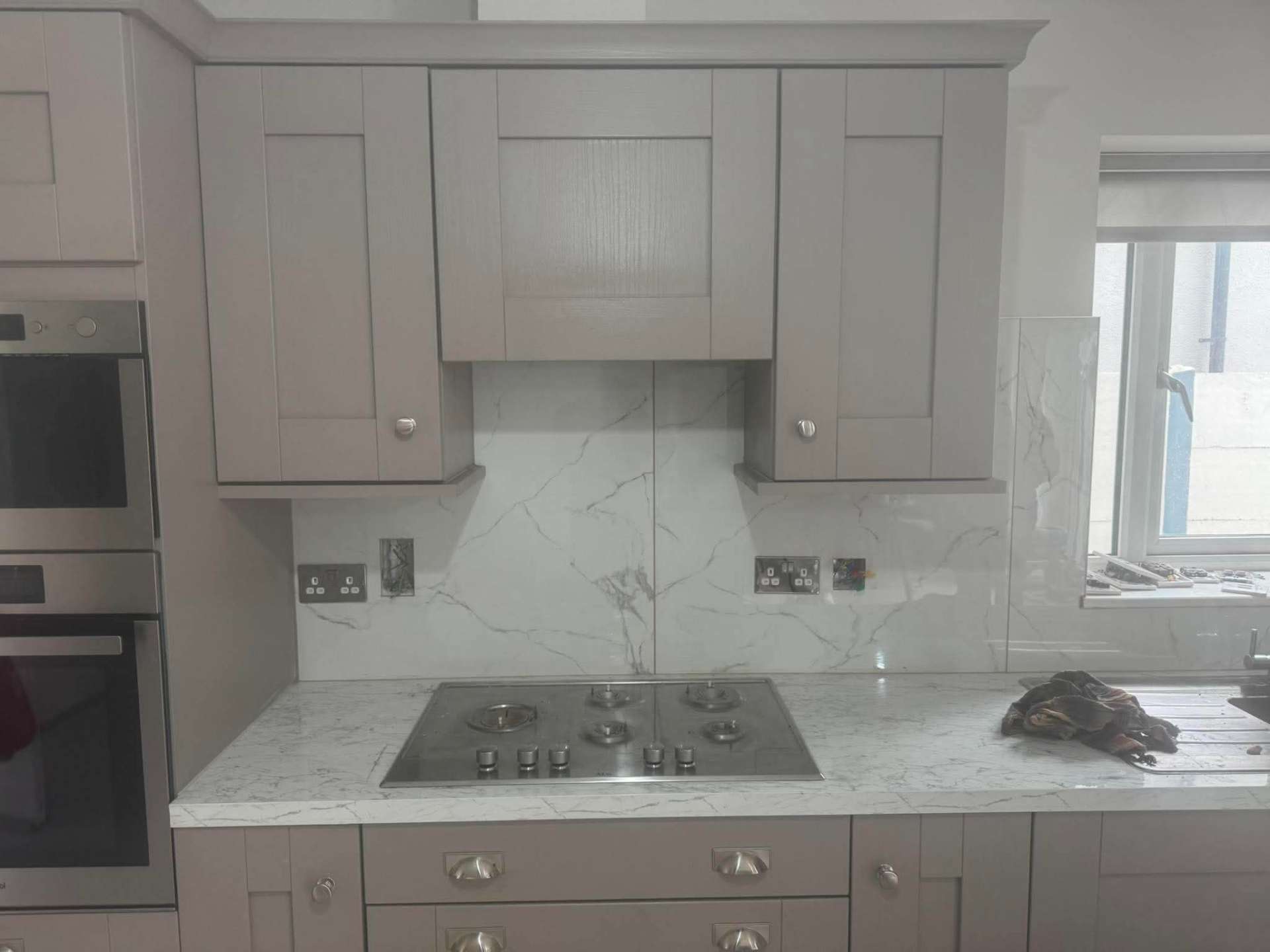Grey shaker — Calacatta splashback set around hood and hob
