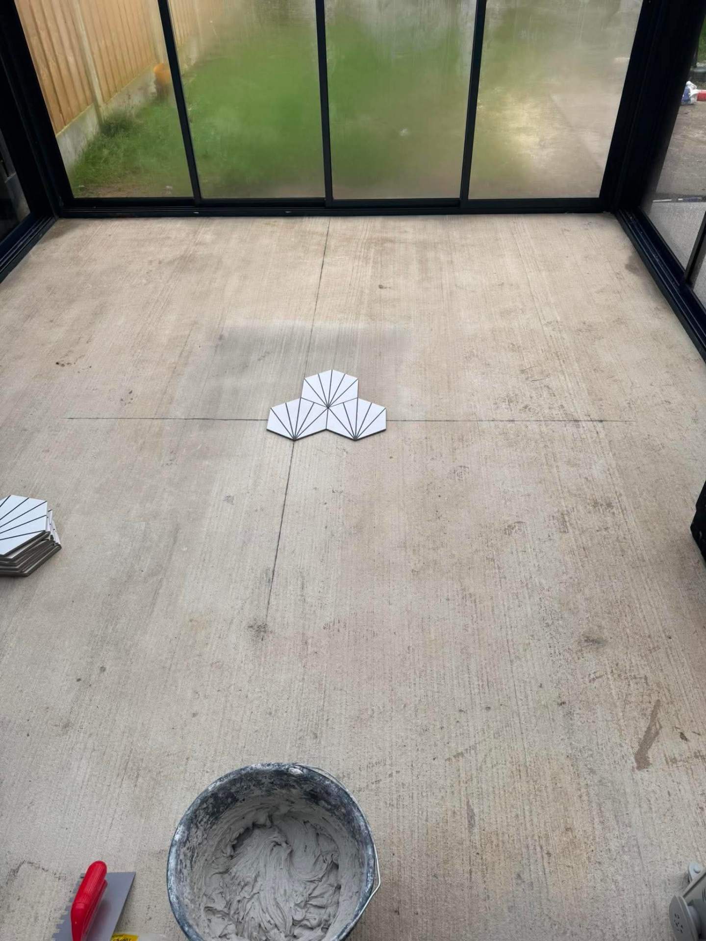 Art-deco fan tile — first pieces being set in an open room