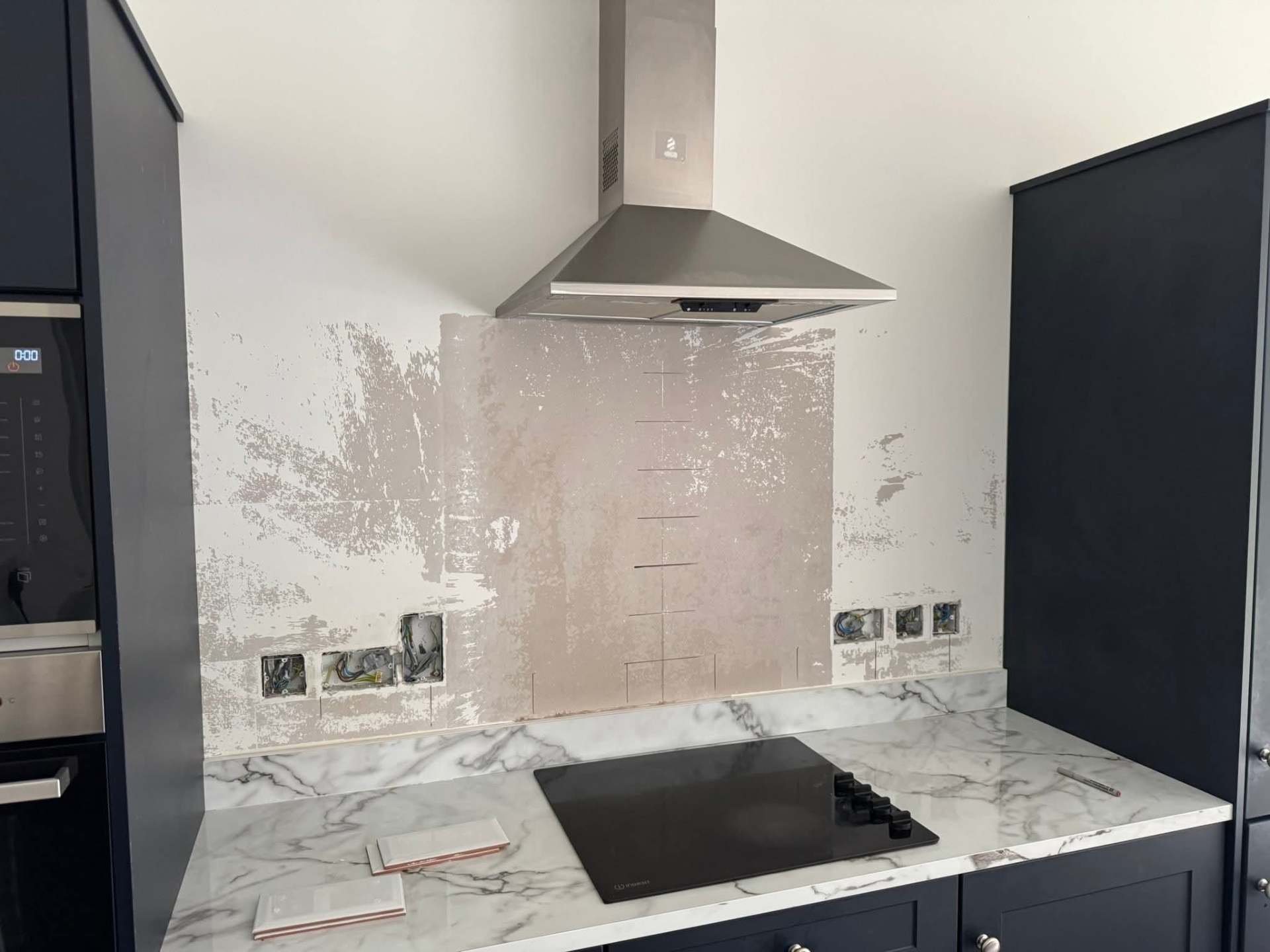 Navy shaker — hood wall stripped to bare plaster for prep