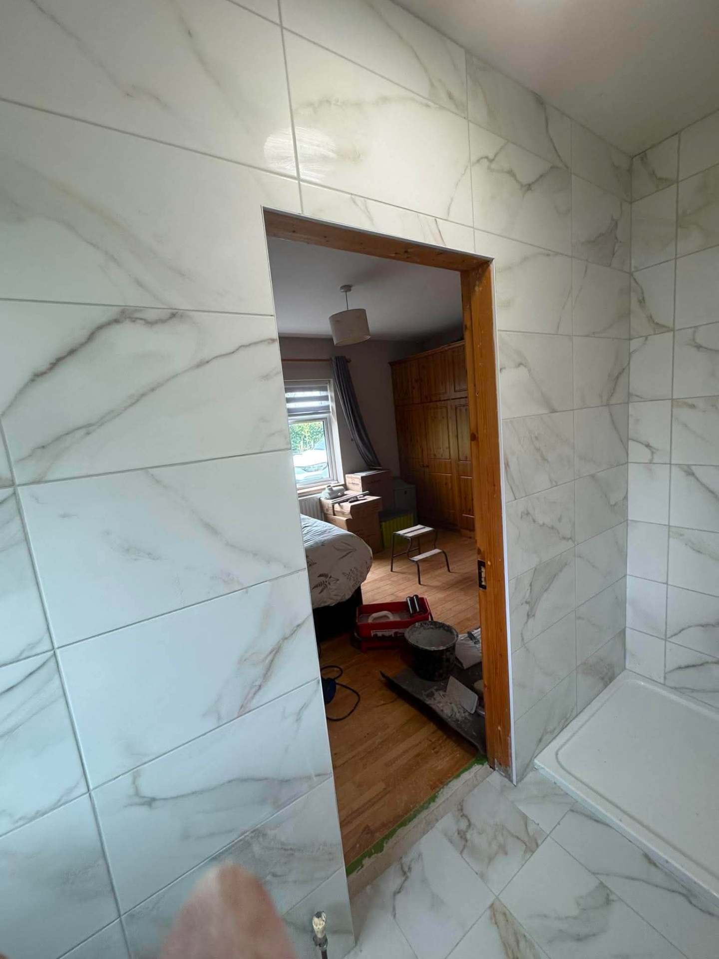 Calacatta marble walls with doorway through to bedroom