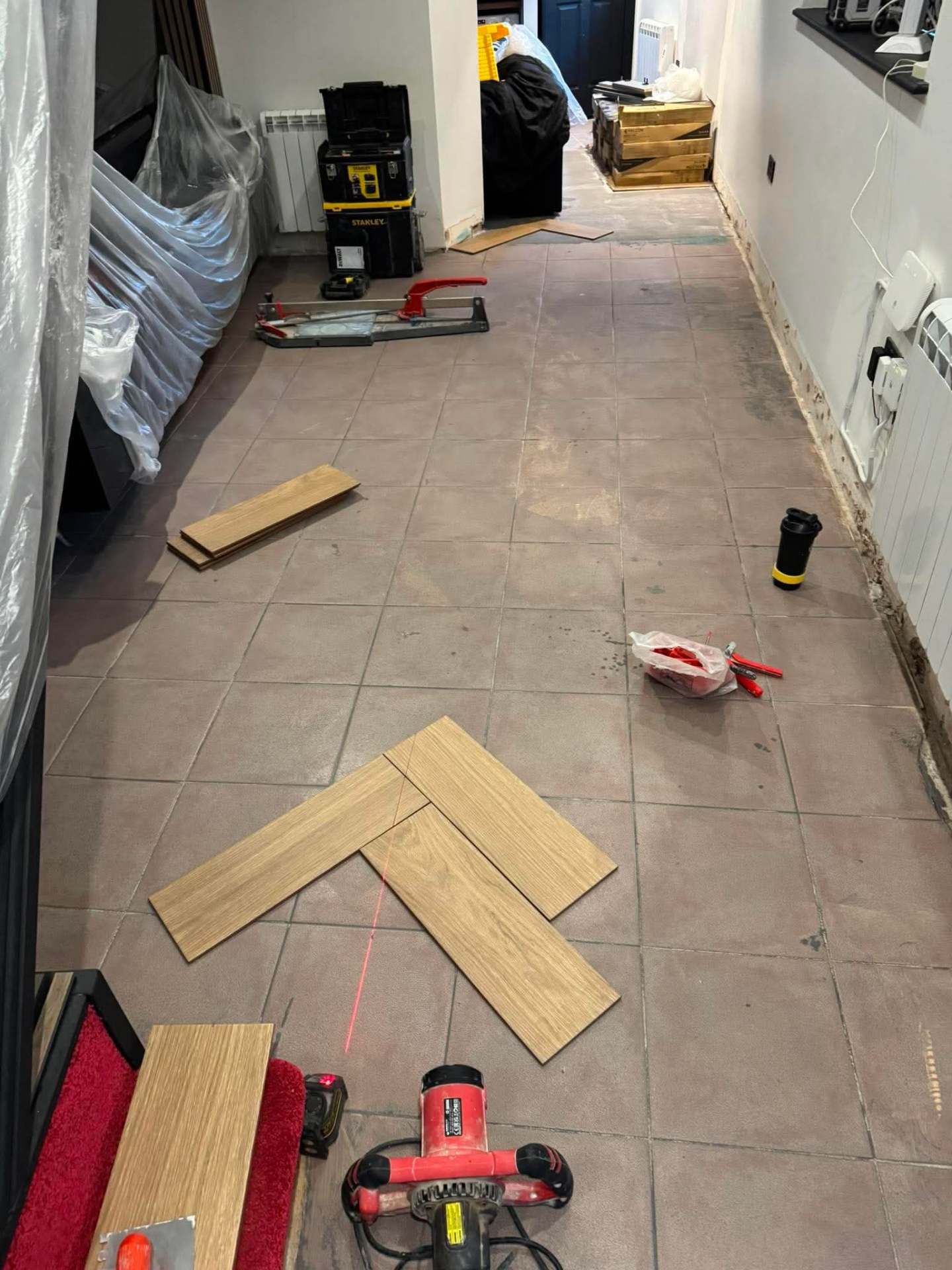 Herringbone install — planks scattered, first courses going in