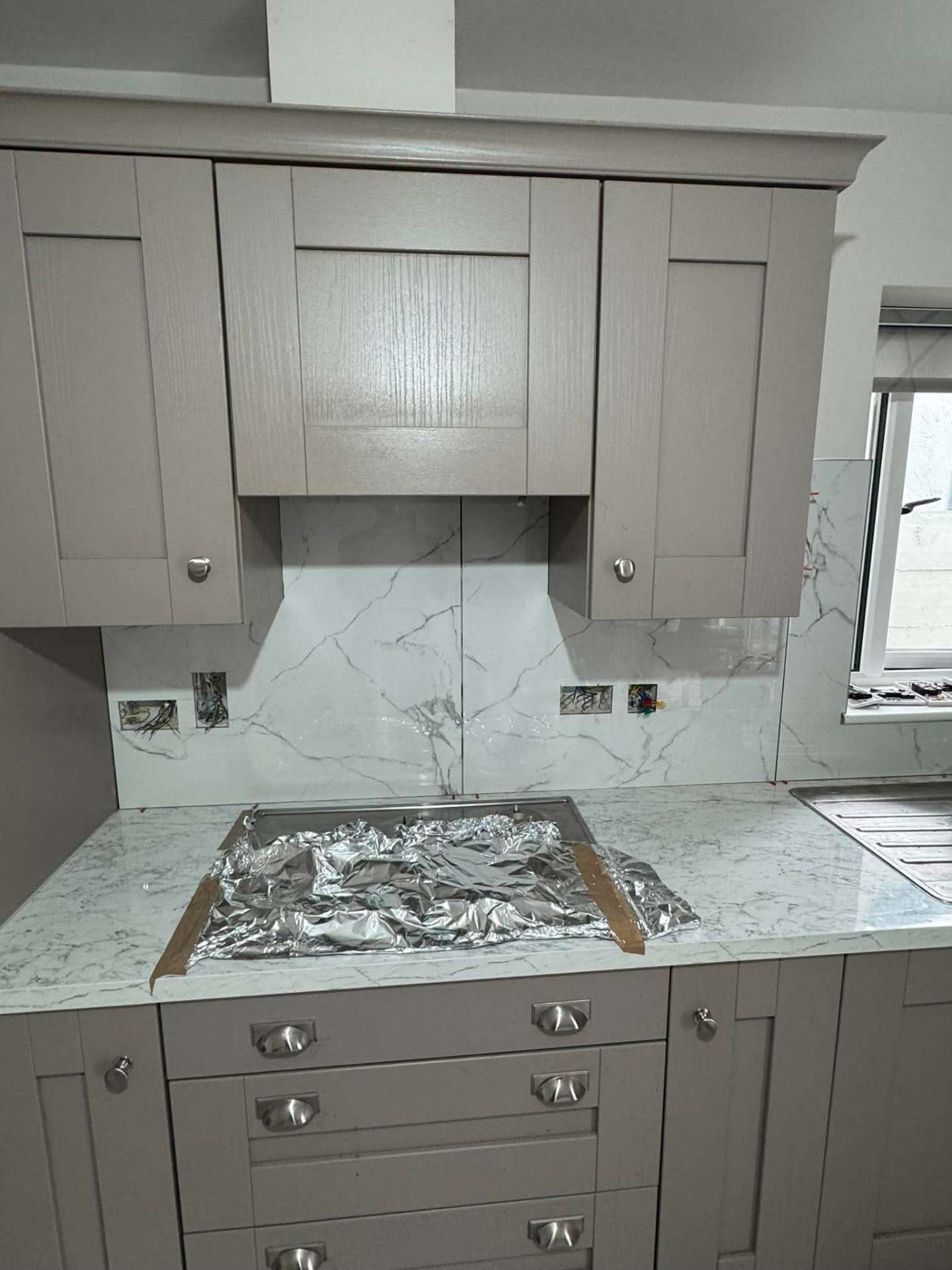 Grey shaker — Calacatta splashback close-up at hood frame