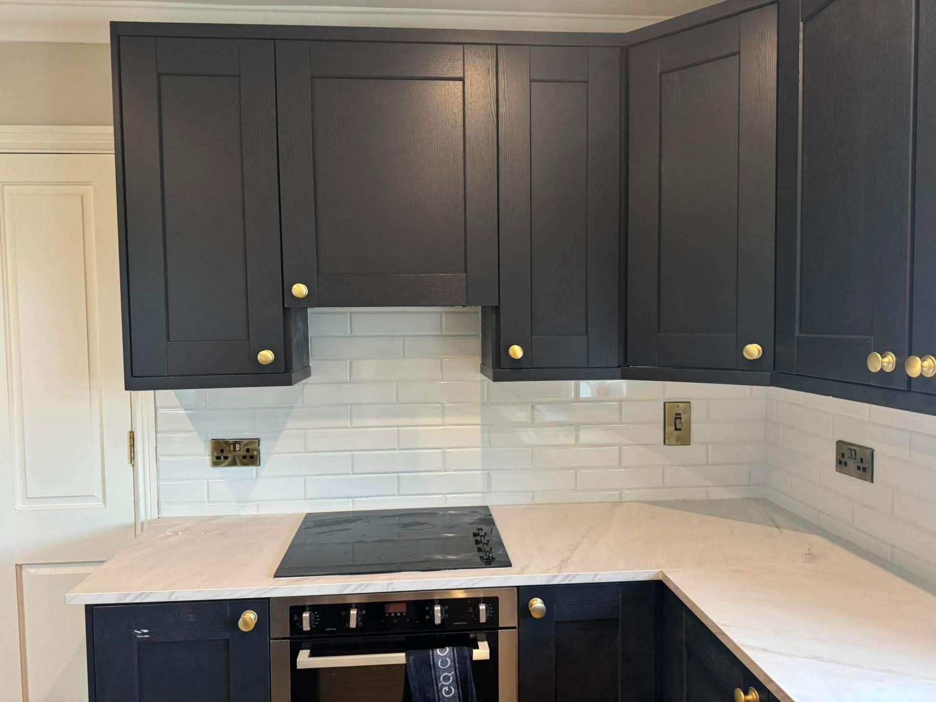 Navy shaker kitchen with bevelled white metro splashback, finished